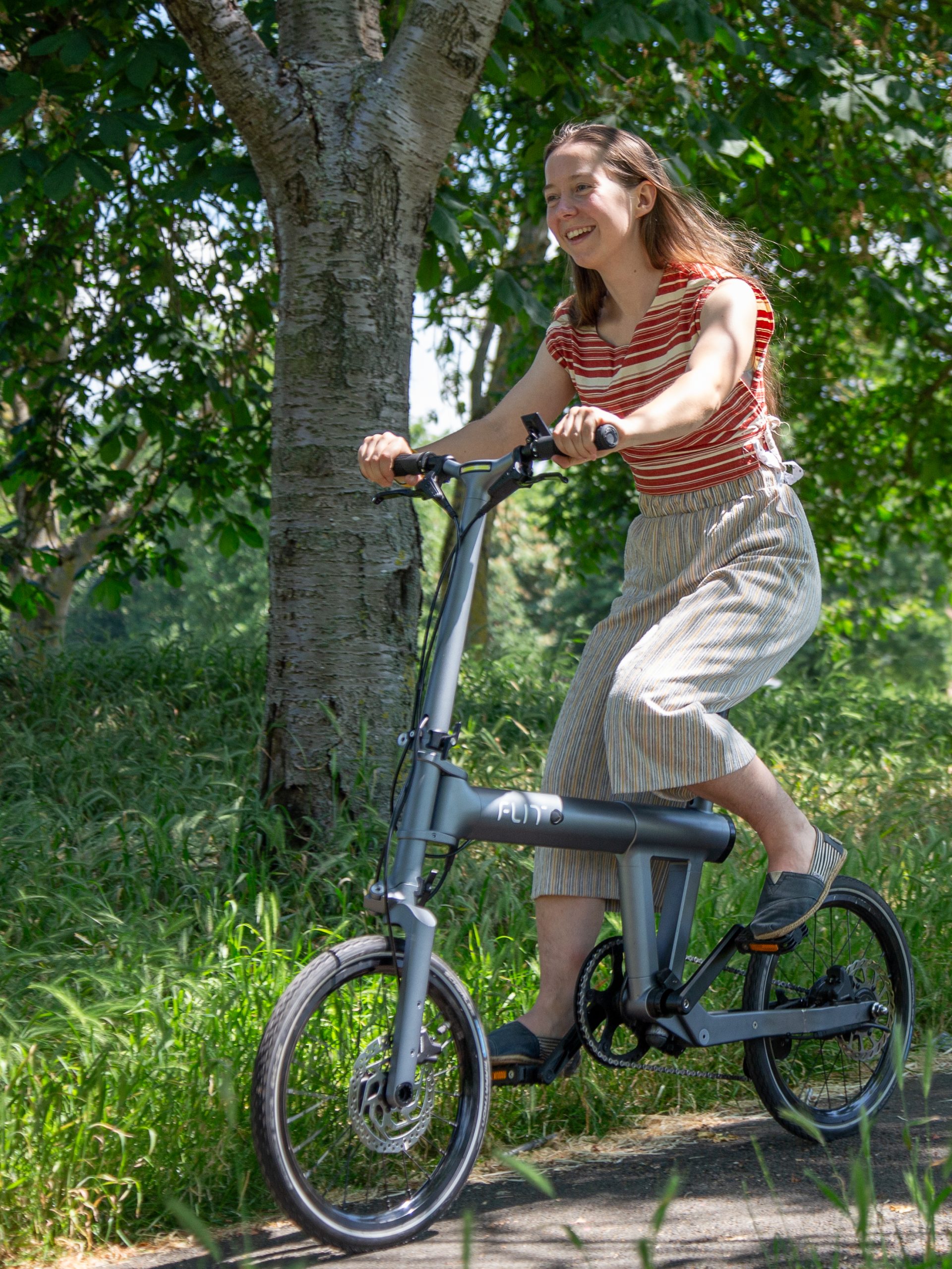Lady riding through the park on a FLIT M2 folding ebike