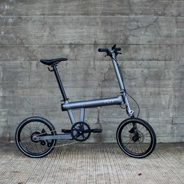 FLIT folding ebike against a grey wall